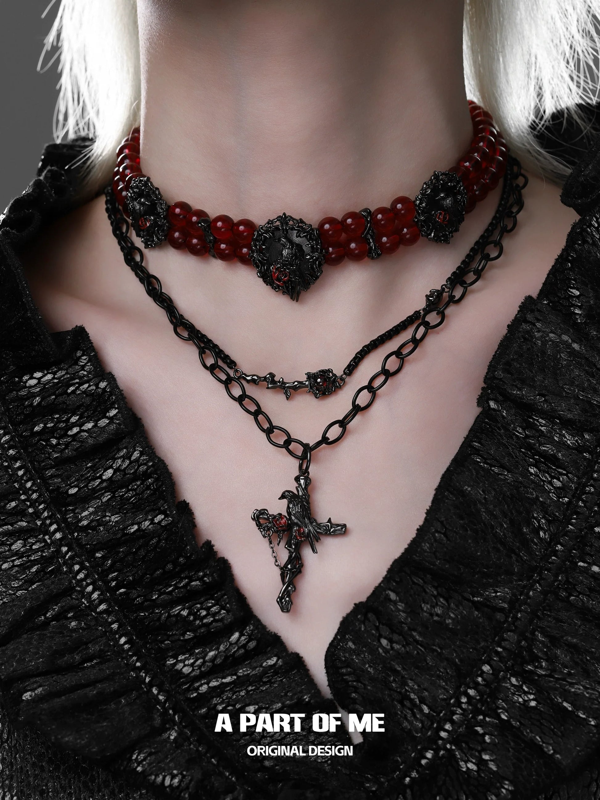 Gothic raven necklace layered with red beads and black chain for a dramatic style