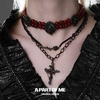 A PART OF ME gothic raven necklace layered with red bead accents for a stylish edgy look