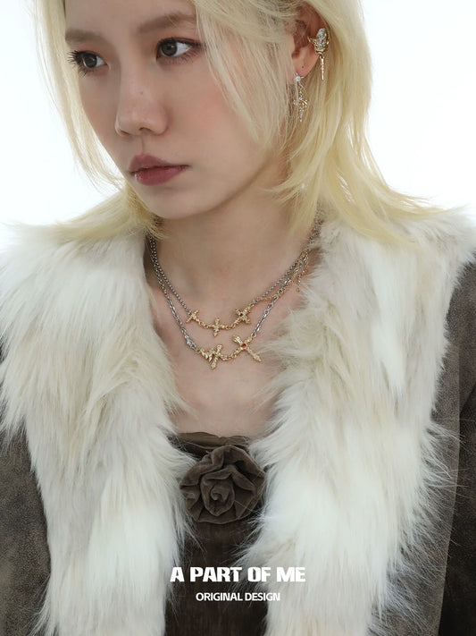 Liquid metal cross necklace layered with delicate chains for a stylish statement look