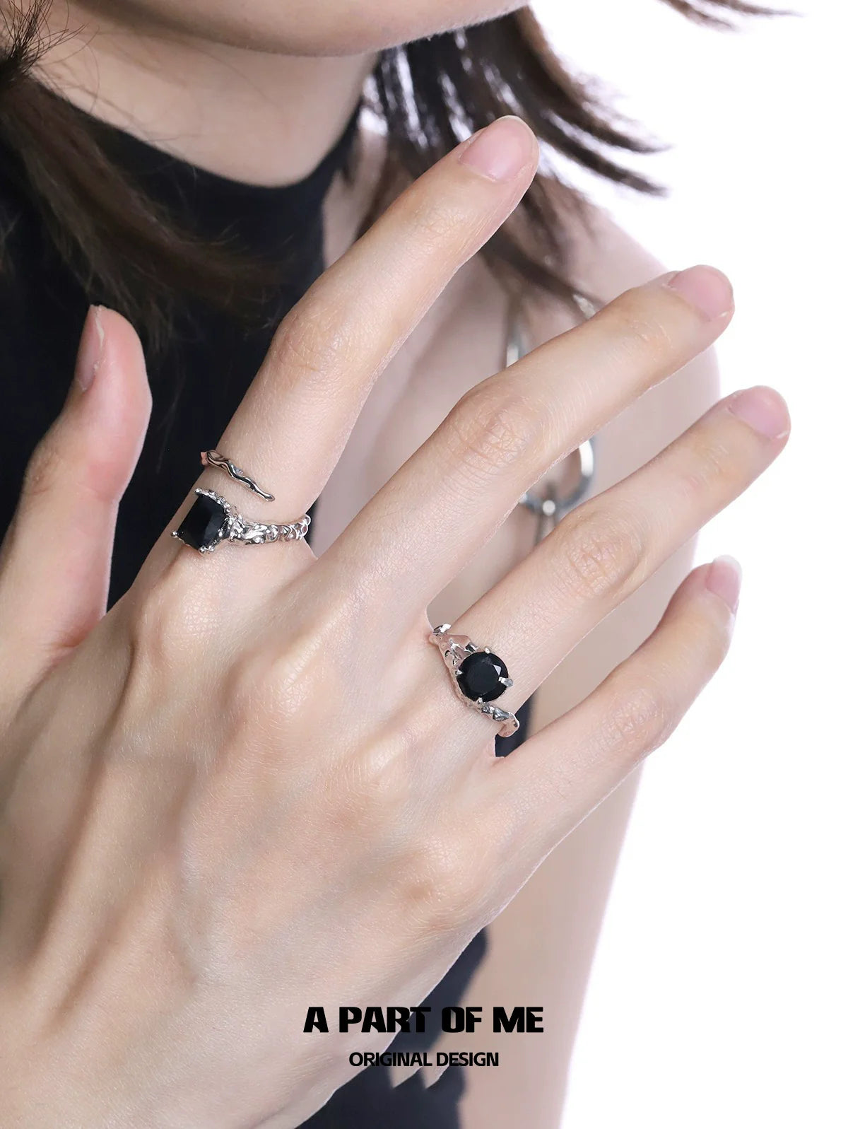 Two elegant midnight gem couple rings on a model's fingers, showcasing unique designs and sparkling stones