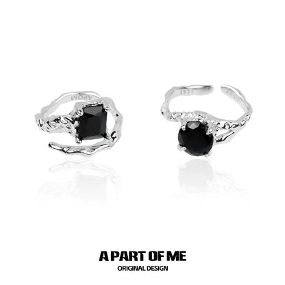 A pair of A PART OF ME midnight gem couple rings featuring black gemstones in a stylish twisted design