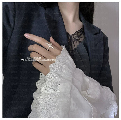 Stylish model wearing a redemption cross silver ring on her finger with elegant lace sleeves