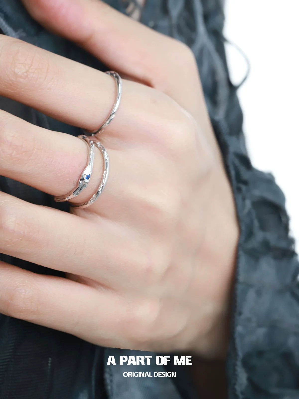 Elegant A PART OF ME ultra-fine zircon pair rings displayed on a hand with textured fabric