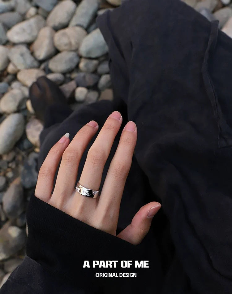 Stylish broken galaxy couple rings from A PART OF ME worn on hand against a rocky background