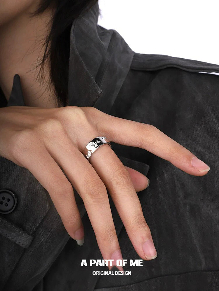 Silver broken galaxy couple rings displayed on a hand with stylish attire