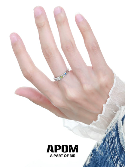 Elegant rainbow gemstone ring displayed on a hand, showcasing vibrant colors and a delicate design