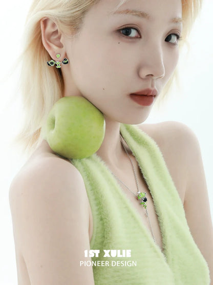Model wearing 1ST XULIE apple cat dog necklace showcased with apple-themed earrings