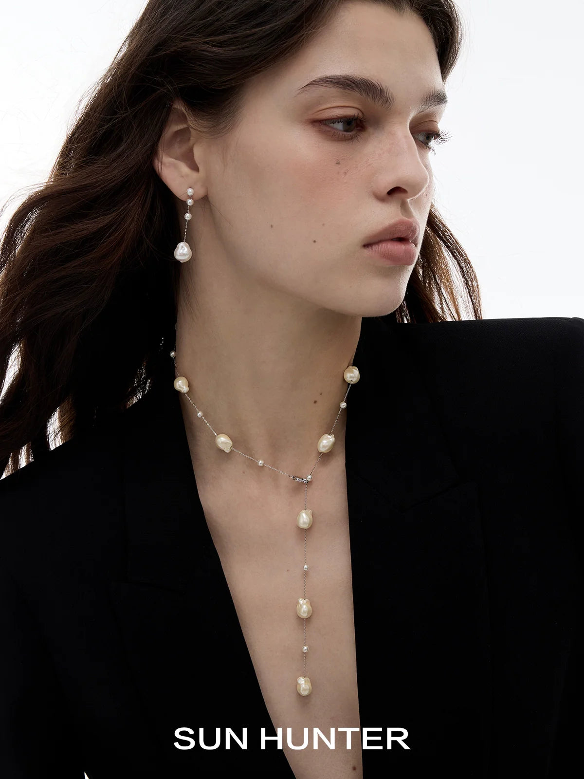 Elegant SUN HUNTER baroque pearl earrings showcased on a model with a sleek hairstyle