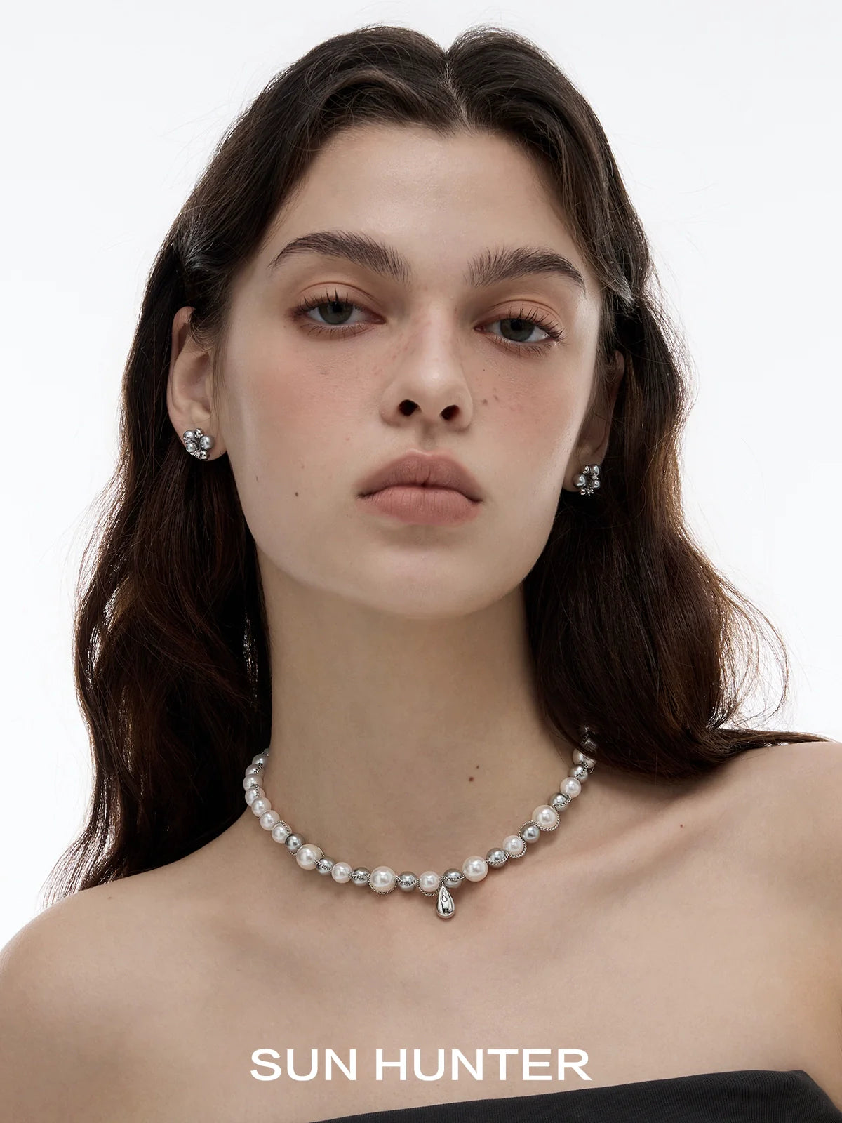 Elegant model wearing black agate earrings paired with a pearl necklace for a sophisticated look
