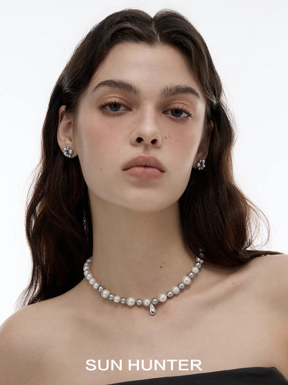 Elegant model wearing black agate earrings paired with a pearl necklace for a sophisticated look