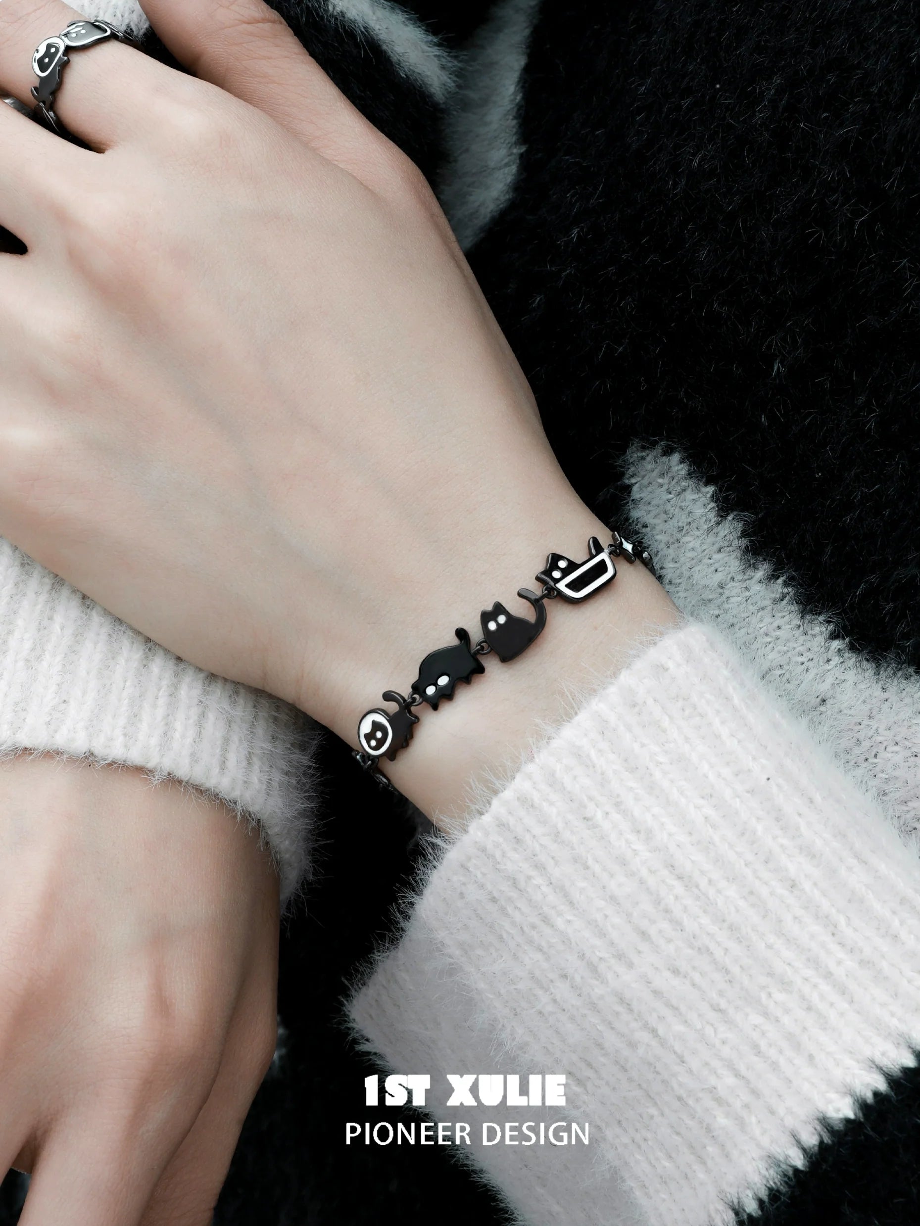 Stylish black cat bracelet featuring playful cat and fish charms, perfect for cat lovers
