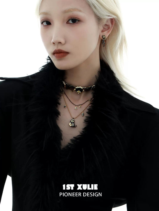 Stylish black gold cat necklace layered with matching earrings and a chic outfit