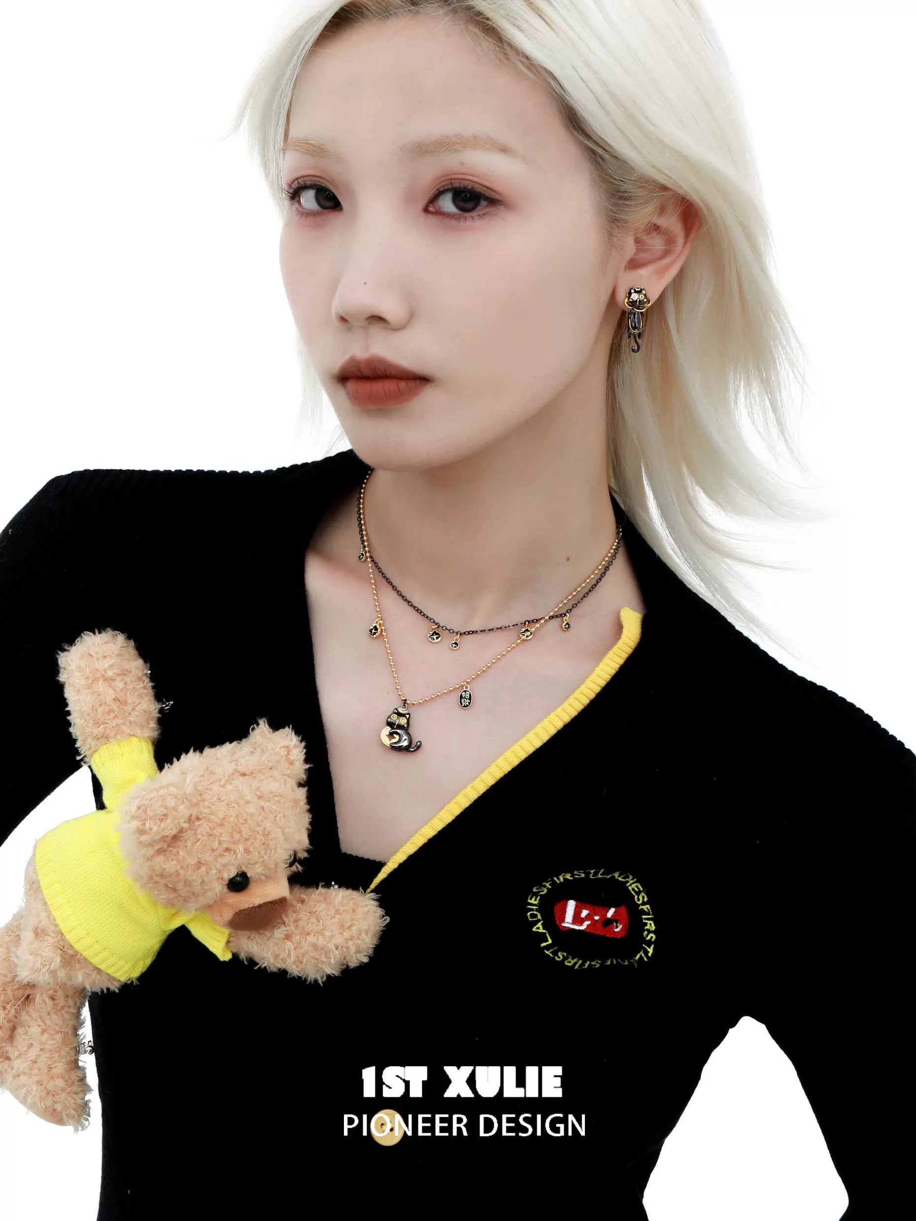 Stylish model wearing a black gold cat necklace layered with other delicate chains