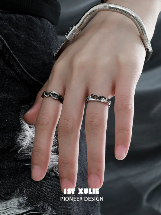 Stylish black snake couple rings on a hand with a snake bracelet and distressed jeans