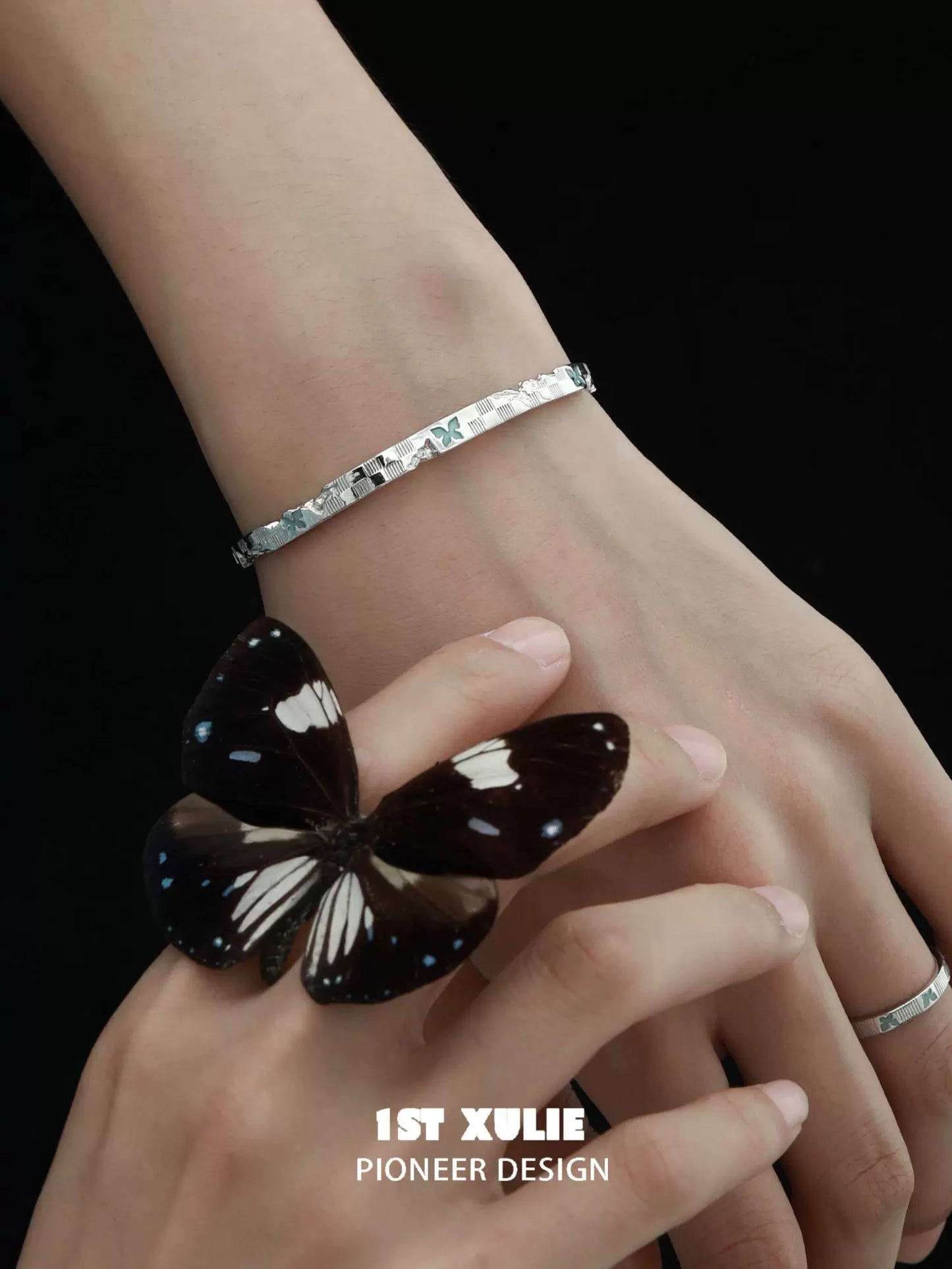 Elegant blue butterfly silver bracelet designed by 1STXULIE on a model's wrist