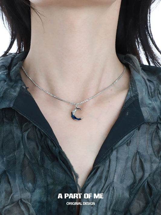 Blue moon pendant necklace by A PART OF ME on a model, features a crescent moon design