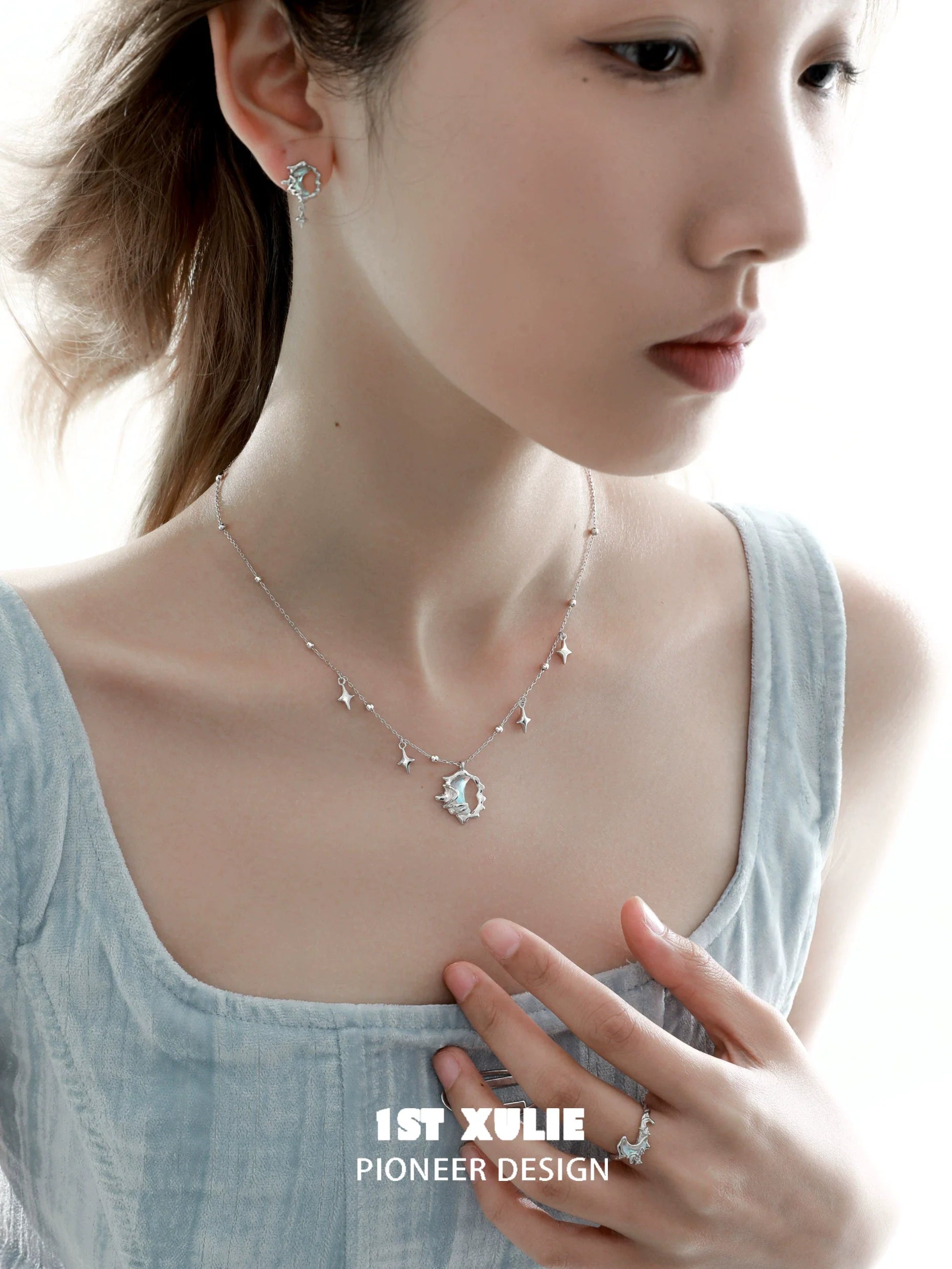 Elegant model showcasing blue moon silver earrings paired with a matching necklace and ring