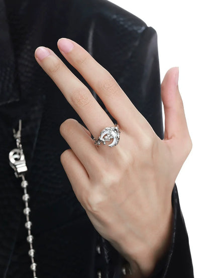 A hand wearing the bone orchid moon ring featuring intricate floral designs in silver