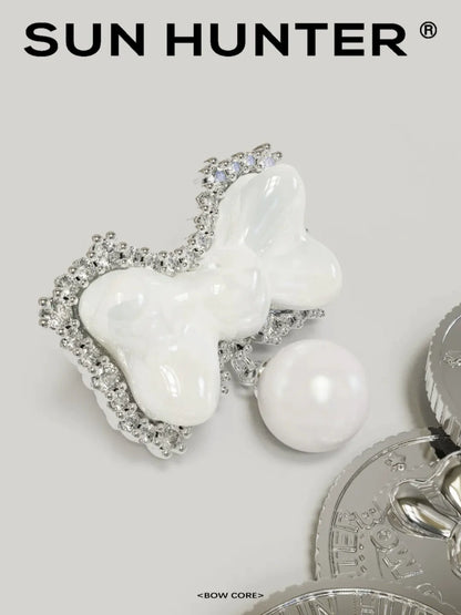 SUN HUNTER bow pearl earrings featuring a bow design with a pearl accent and sparkling details