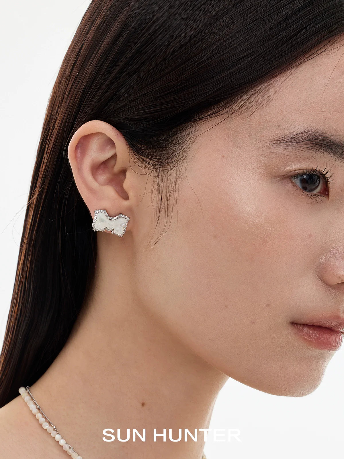 Elegant SUN HUNTER bow pearl earrings with a unique design, enhancing any outfit