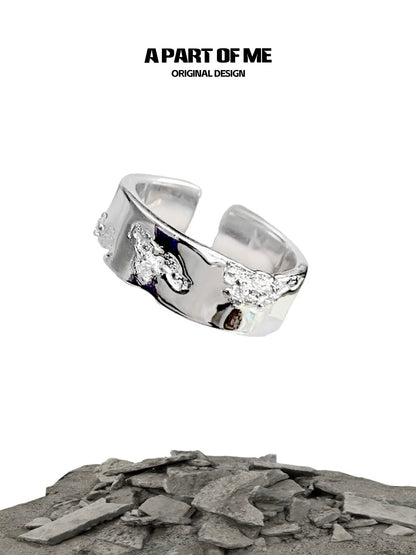 A PART OF ME broken silver ring with unique texture and original design showcased on a rocky background