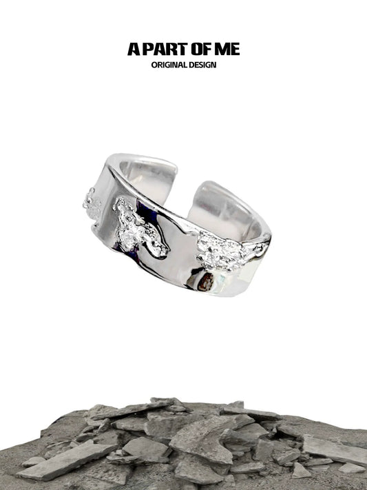 A PART OF ME broken silver ring with unique texture and original design showcased on a rocky background