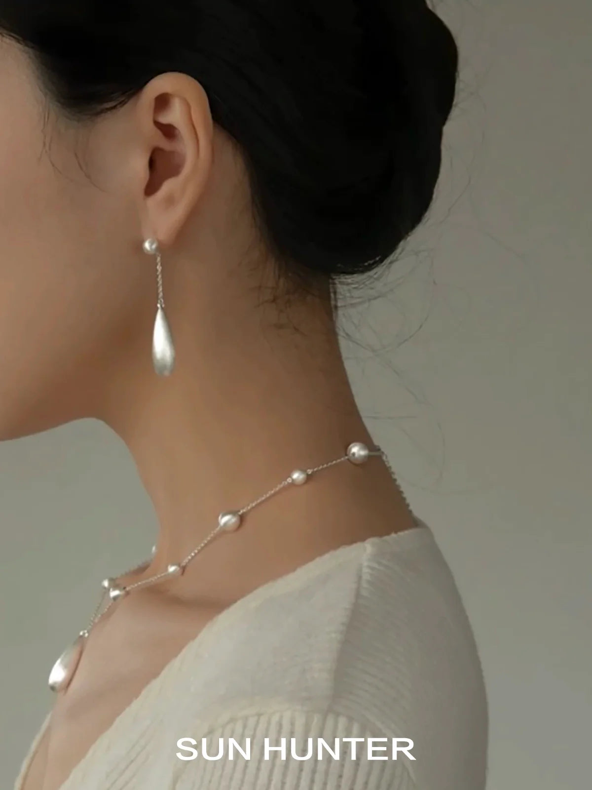 Elegant SUN HUNTER brushed teardrop earrings showcased on a model for a stylish look