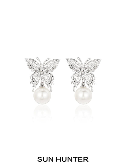 Elegant SUN HUNTER butterfly pearl earrings featuring a silver butterfly design and lustrous pearls