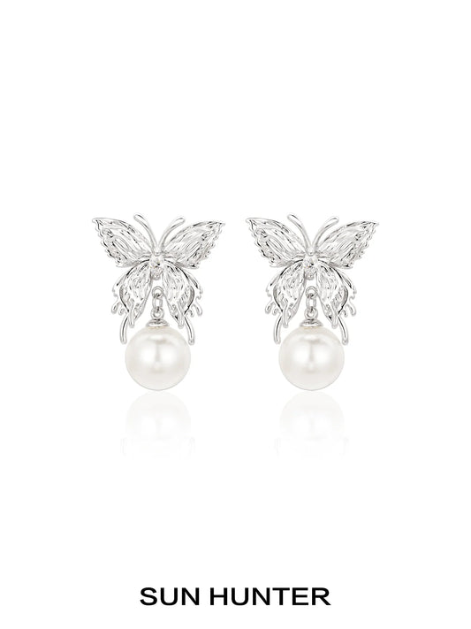 Elegant SUN HUNTER butterfly pearl earrings featuring a silver butterfly design and lustrous pearls