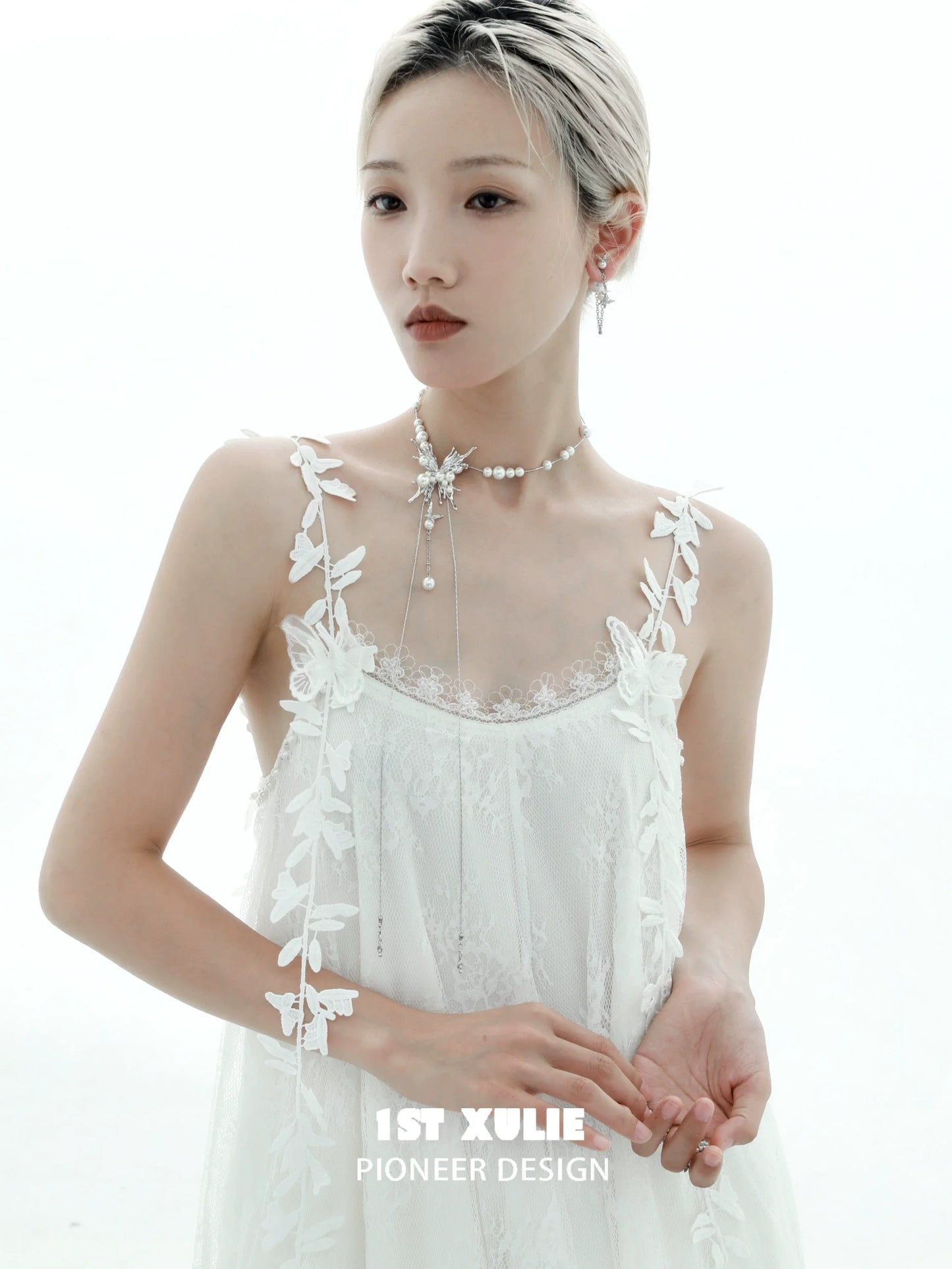 Elegant butterfly pendant necklace from 1STXULIE worn with a delicate white dress