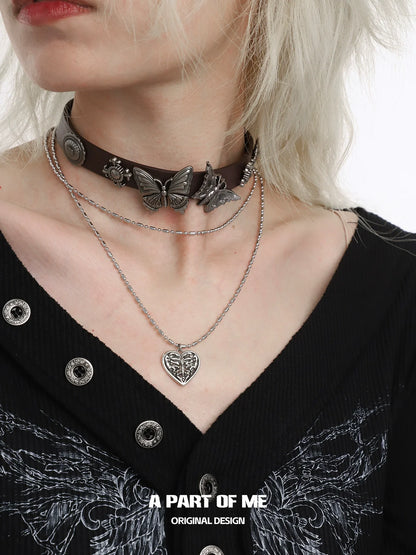 A PART OF ME butterfly punk necklace layered with a leather choker and silver chain for a stylish look