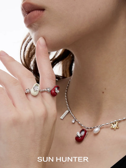 SUN HUNTER butterfly shoe rings featuring colorful designs and sparkling accents worn on a model's finger