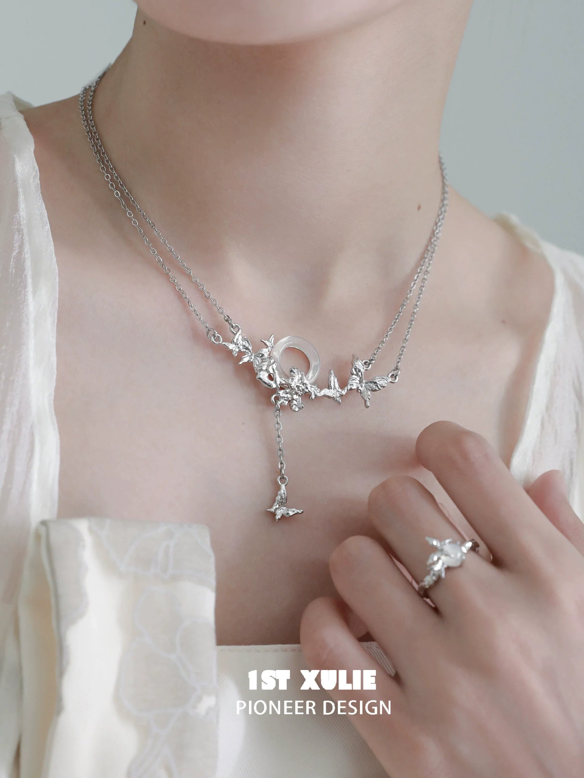 Delicate butterfly silver necklace from 1STXULIE with layered design and elegant charm