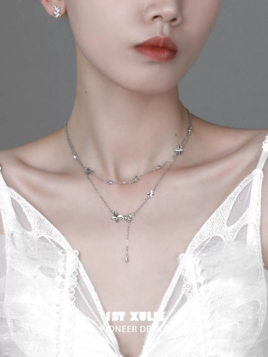 Elegant butterfly silver necklace layered design showcased on a model wearing a white dress