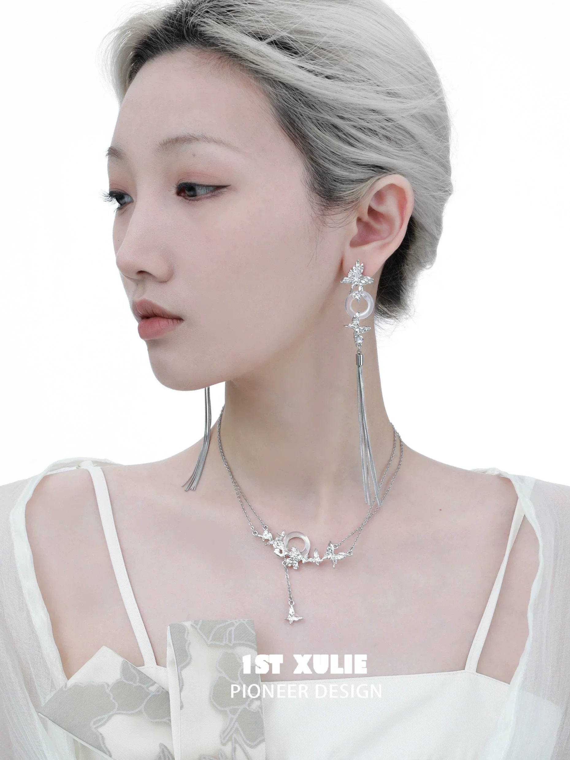 Elegant butterfly silver necklace worn by model with stylish earrings and chic outfit