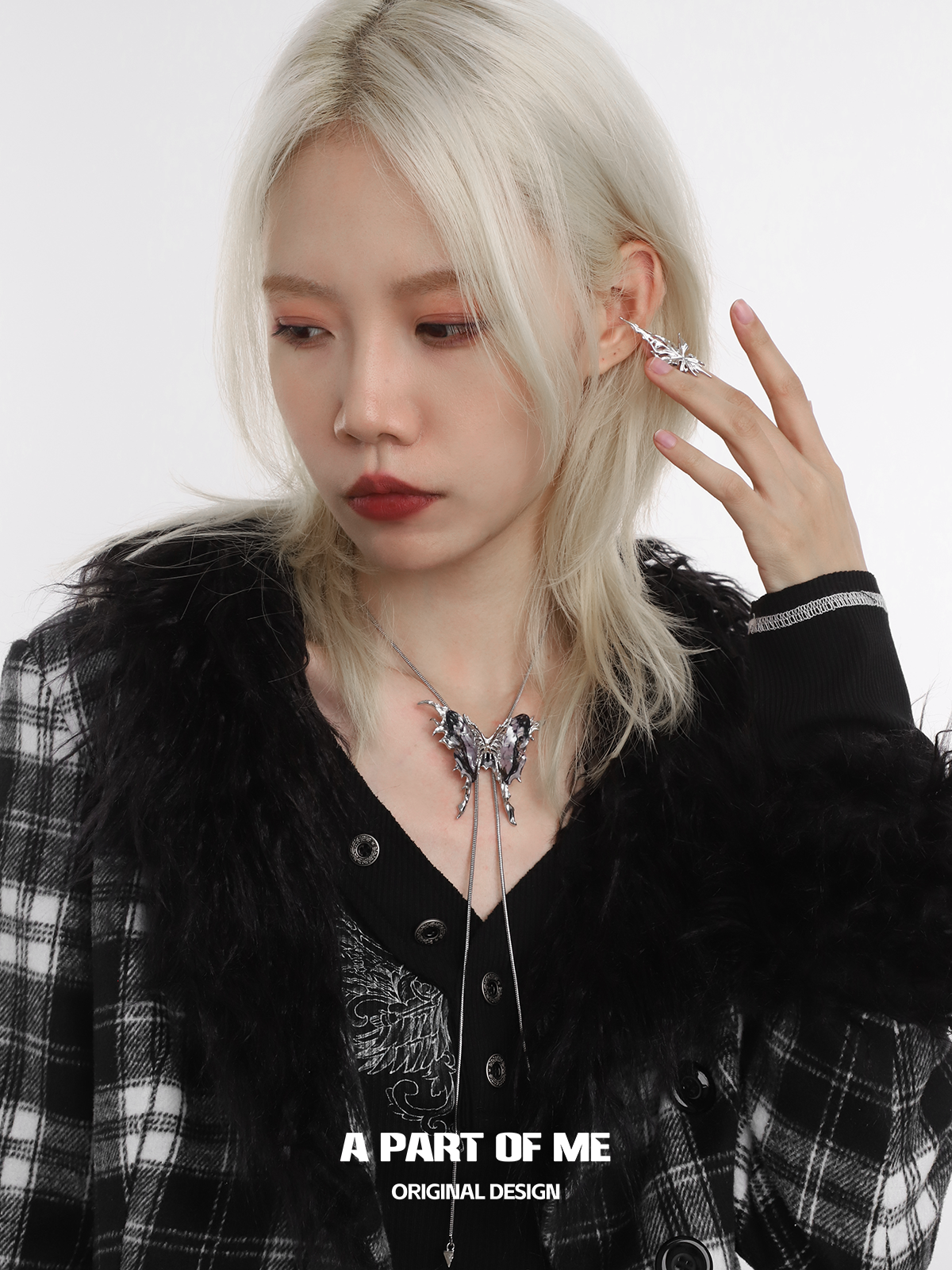 A stylish butterfly silver ring showcased by a model wearing a chic layered outfit