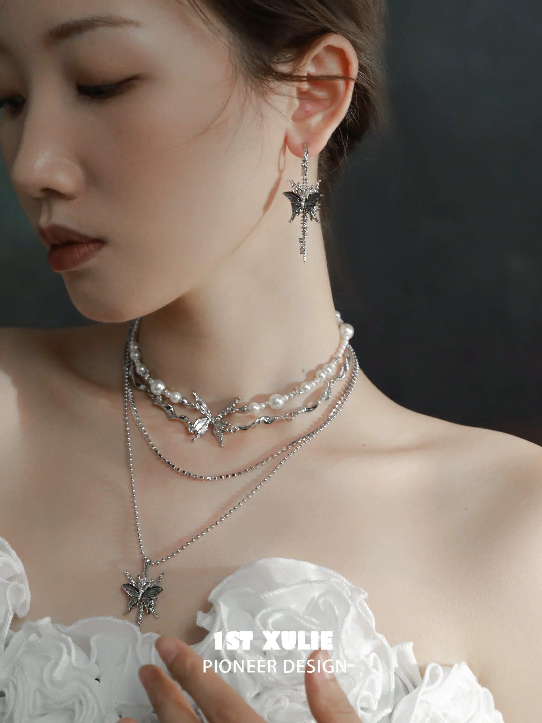 Elegant butterfly tassel shell earrings showcased with layered pearl necklaces for a chic look
