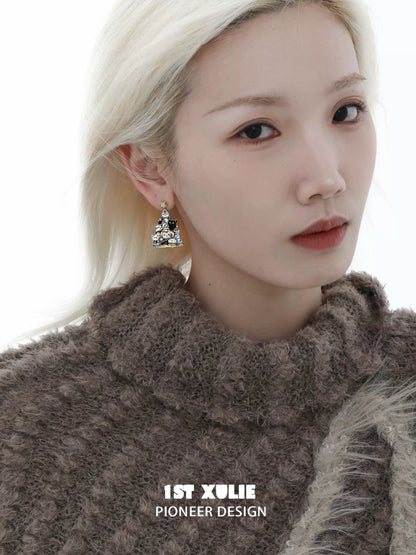 Elegant cat family silver stud earrings displayed on a model with soft features and a cozy sweater