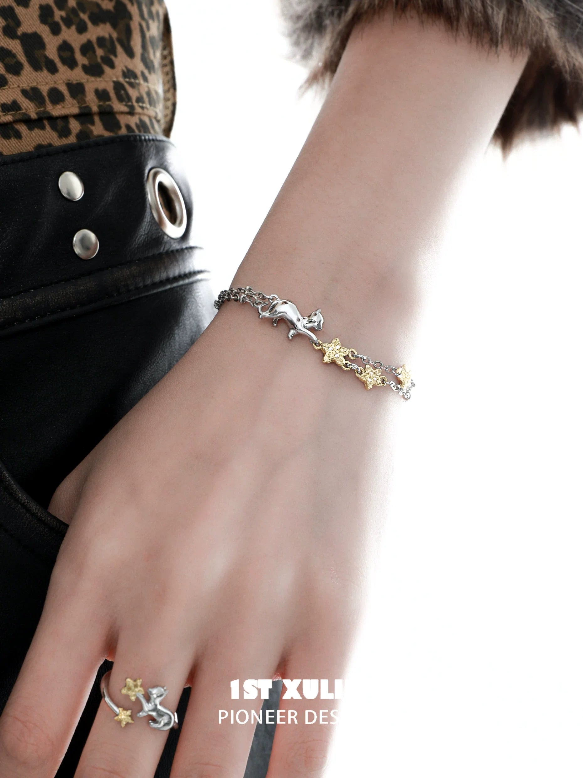 1STXULIE cat star bracelet in silver and gold tones worn on a hand with stylish clothing.