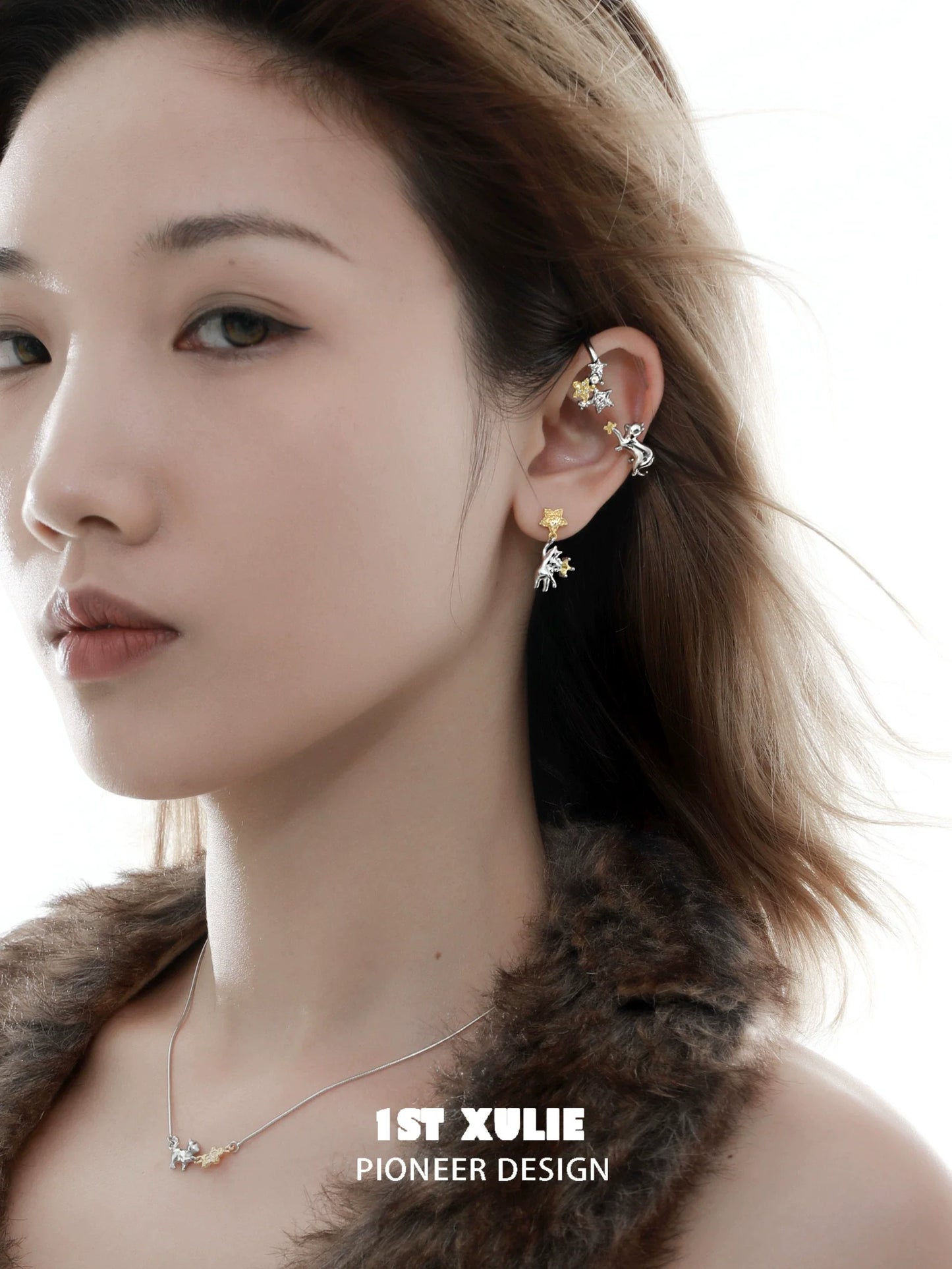 Model wearing stylish cat star earrings in gold and silver, showcasing a unique design