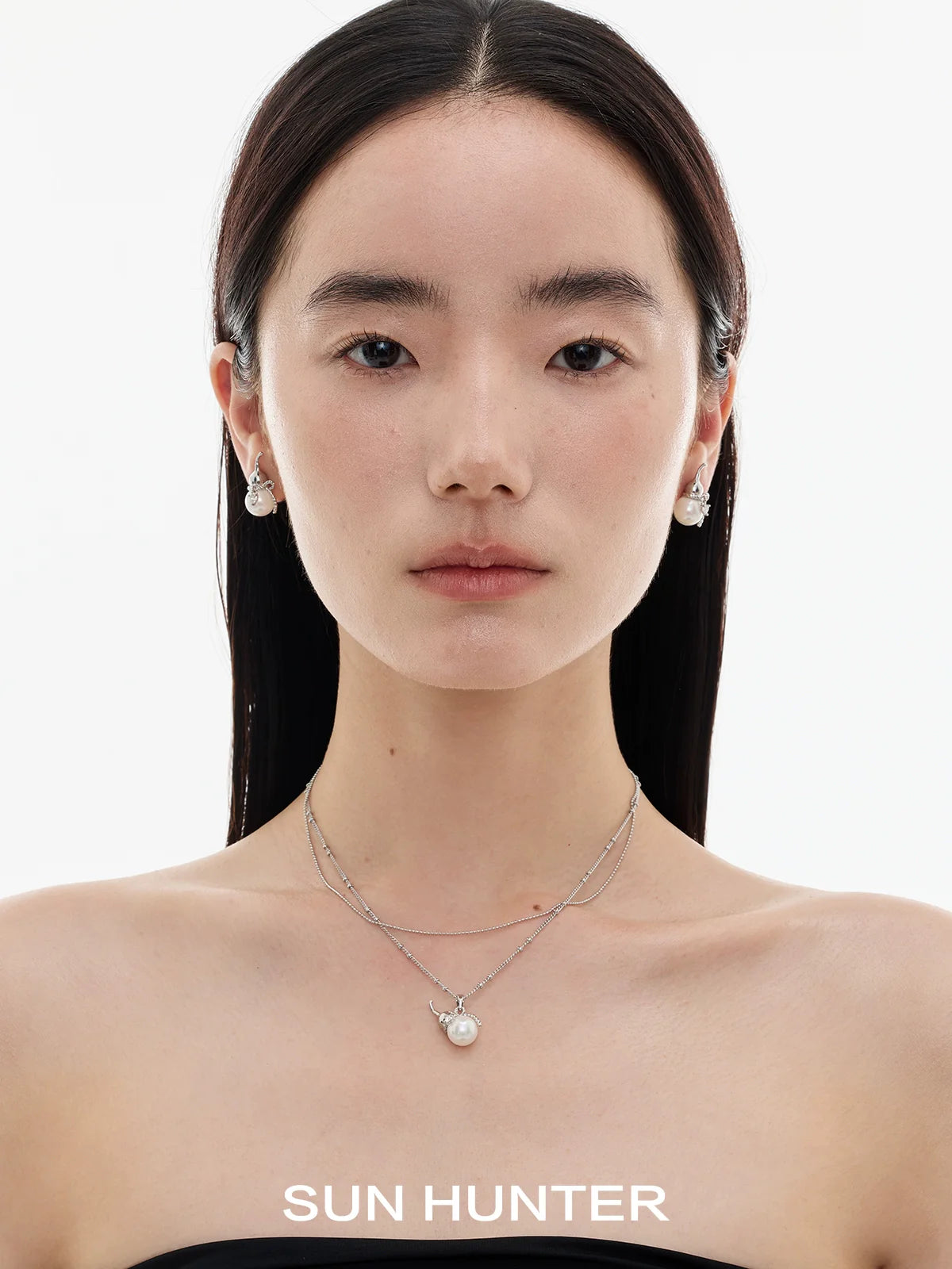 Elegant model wearing SUN HUNTER Chinese fortune gourd earrings styled with a minimalist necklace