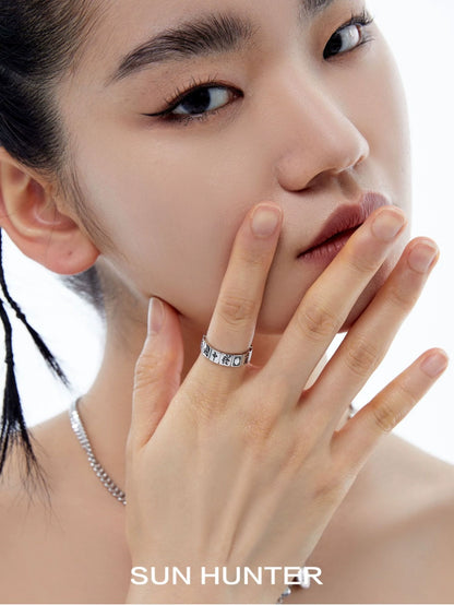 Close-up of a model wearing a SUN HUNTER Chinese Mahjong ring with intricate design and shiny finish