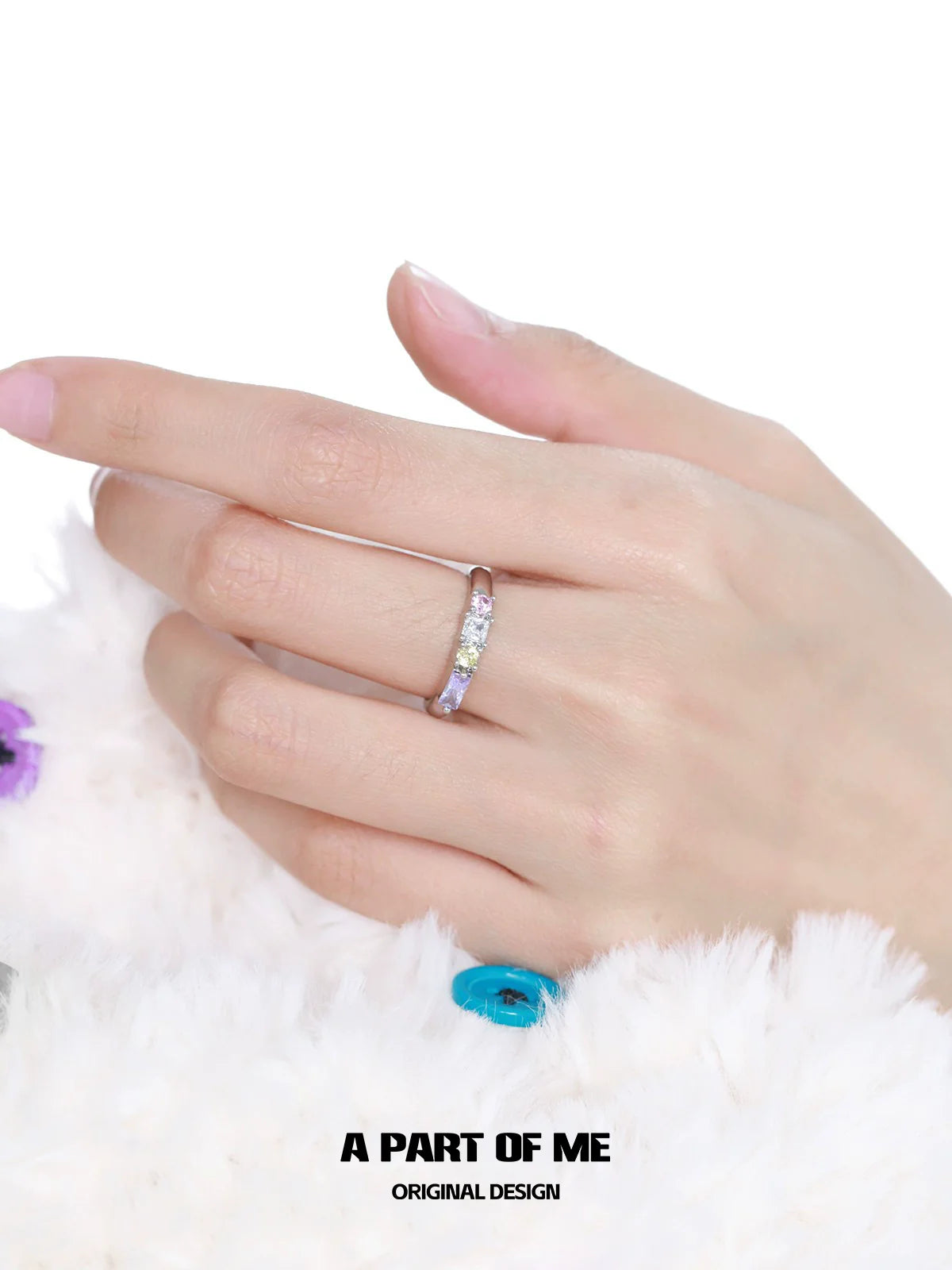 A hand wearing a colorful zircon ring featuring multiple sparkling stones for a stylish look