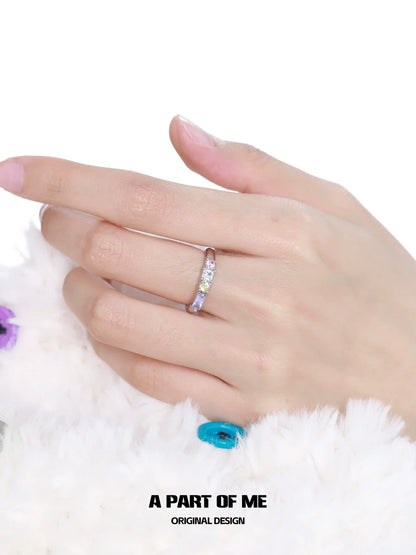 A hand wearing a colorful zircon ring featuring multiple sparkling stones for a stylish look