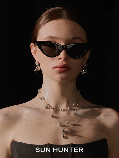 Stylish model wearing cosmic planet earrings set and black cat-eye sunglasses for a chic look