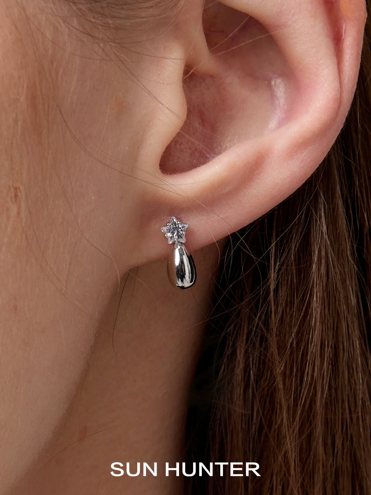 Silver SUN HUNTER cosmic planet earrings set on a model's ear for a stylish and modern look