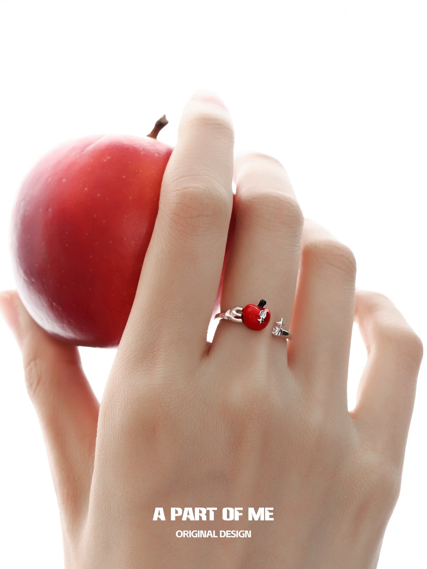 Cute apple ring by A PART OF ME showcased on a hand holding a red apple