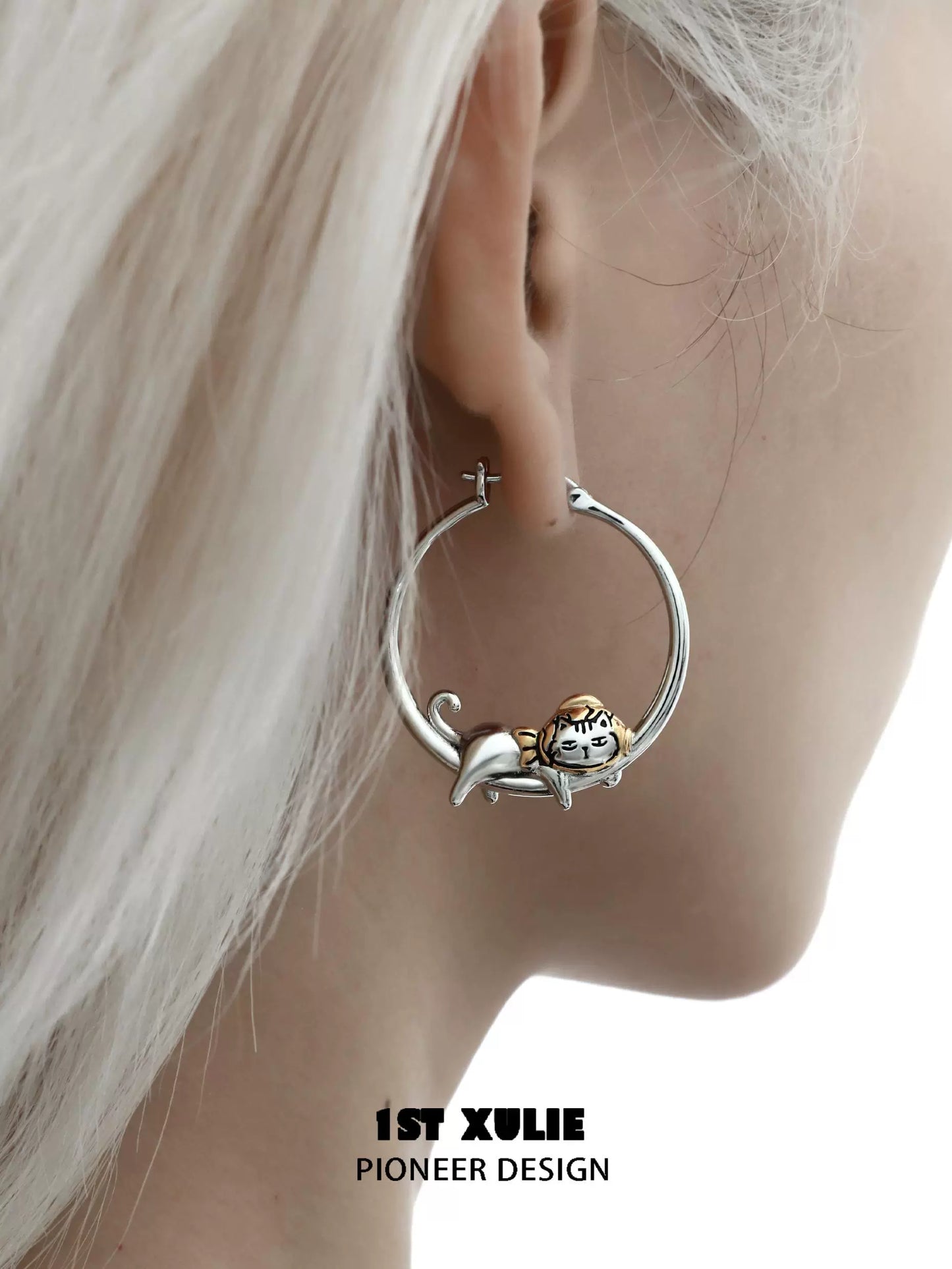 Cute cat hoop earrings designed by 1STXULIE featuring a playful cat sitting on the hoop