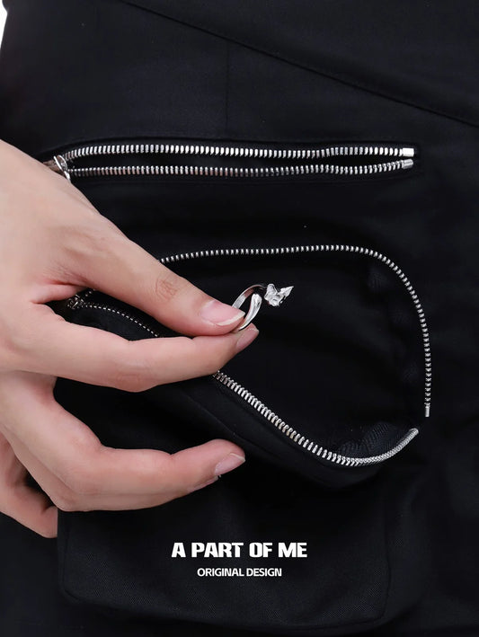 Hand holding a cute cat tail silver ring next to stylish pockets showcasing innovative design
