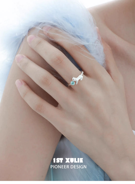 Cute kitten silver ring featuring a blue gemstone accent, worn on a hand for a stylish look